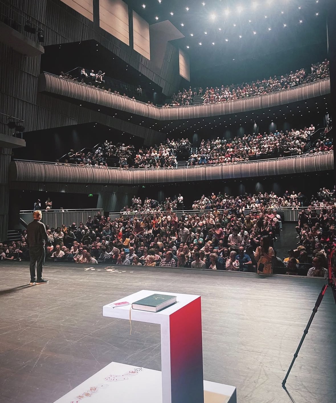 Nicholas Arnst facing a large theatre audience